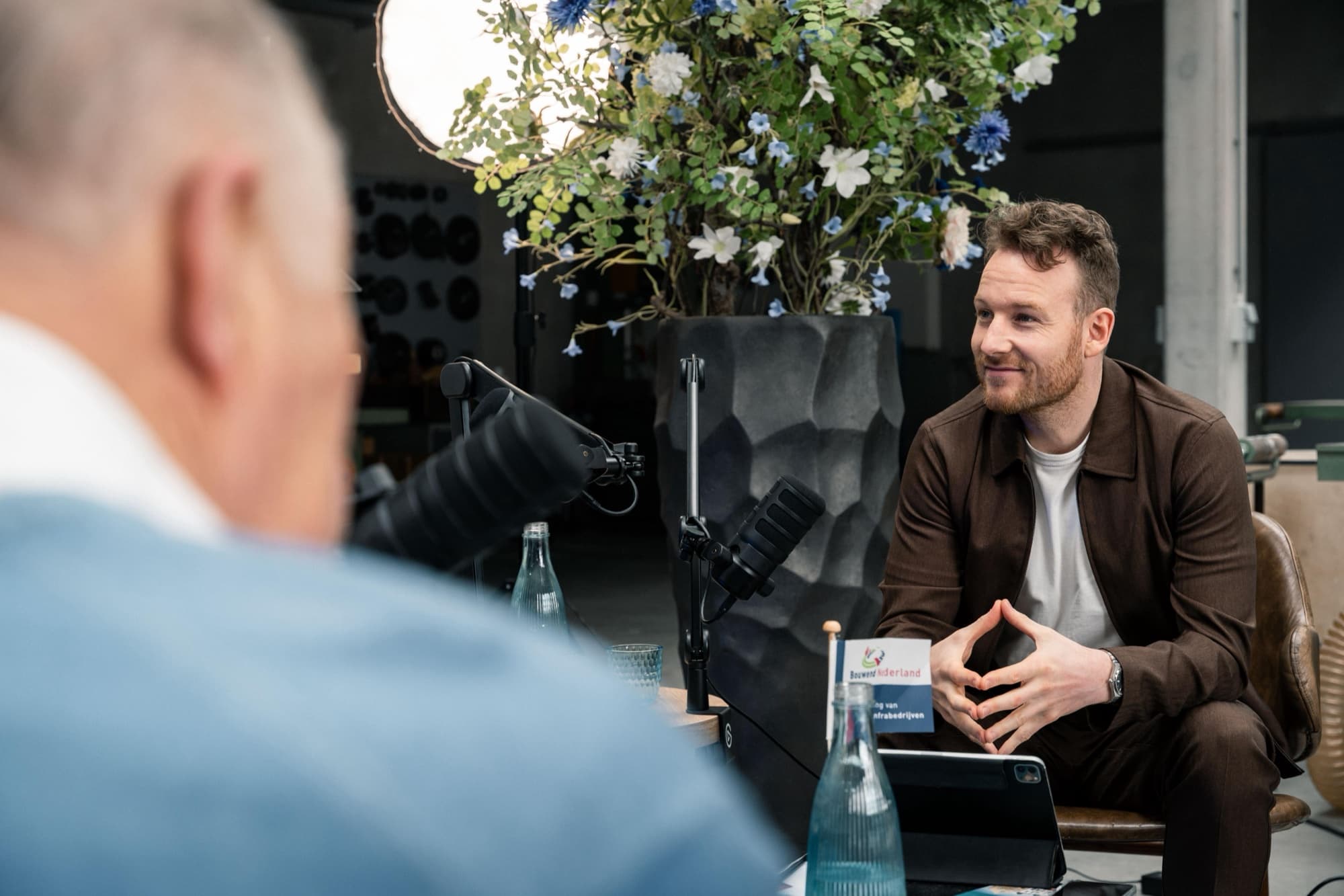 Rudy Nicola in gesprek met een gast tijdens een podcastopname